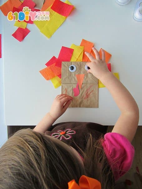 Toddler making Thanksgiving paper bag turkey