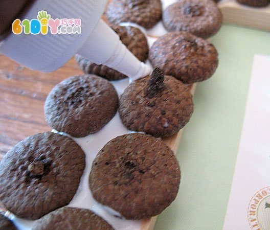 Children use acorn hats to make photo frames by hand