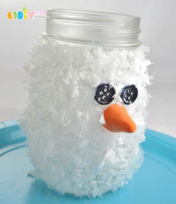 Child making glass bottle snowman lantern