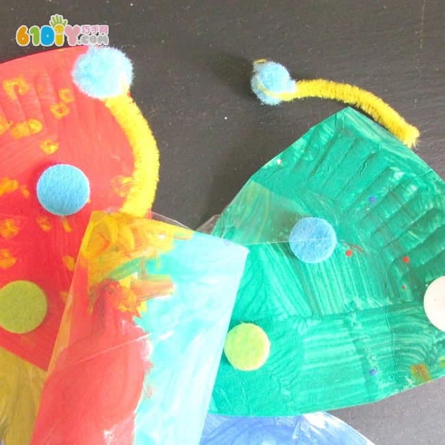 Children make colorful butterflies using paper trays