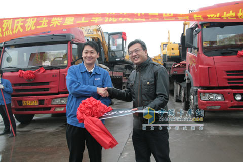 Zhang Shiyong delivers the key of the excavator to Feng Jinhua