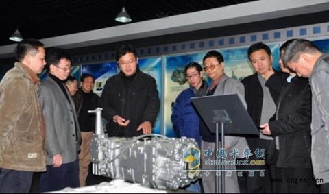 The picture shows the deputy general manager of Lufang Transmission Co., Ltd. Liu Yudong (former left third) introduces the general situation of the 2200Nm synchronous-type planetary transmission of heavy-duty commercial vehicles independently developed and produced by the company to the members of the expert acceptance group.