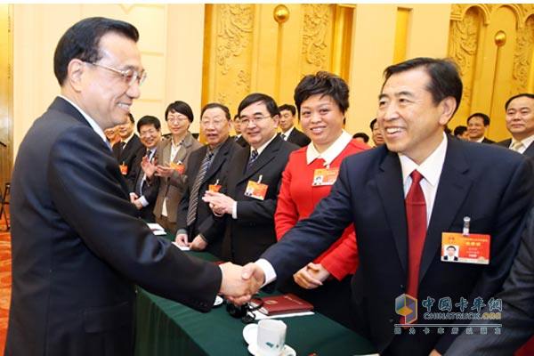 Premier Li Keqiang shakes hands with representatives of the two associations
