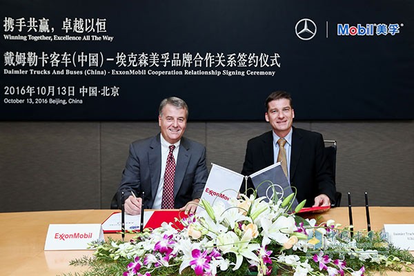 Dr. Rainer Gaertner, president and CEO of Daimler Trucks (China) Co., Ltd. (right) and Tim Hinchman (left), president of ExxonMobil's global strategic customers sales, took photos at the signing ceremony.