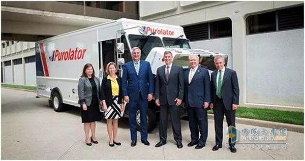 Indiana State Governor Eric Holcomb (third from left) visits the Cummins Technology Center and takes a picture with the Cummins management before the pure electric trucks are being debugged.
