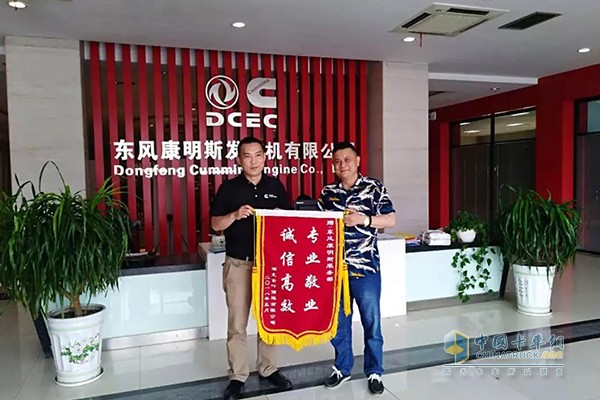 A banner printed with the words â€œprofessional, dedicated, honest, and efficientâ€ was handed to Gui Lijia, head of the customer department of Dongfeng Cummins Group.