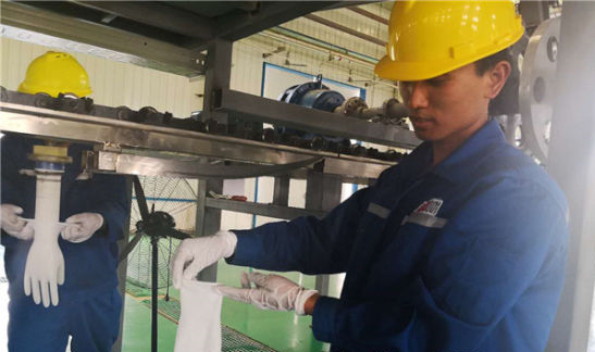 The picture shows the production line workers show waterborne polyurethane surgical gloves. Shi Jingjing