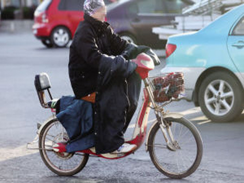 The woman wears an electric car against her clothes