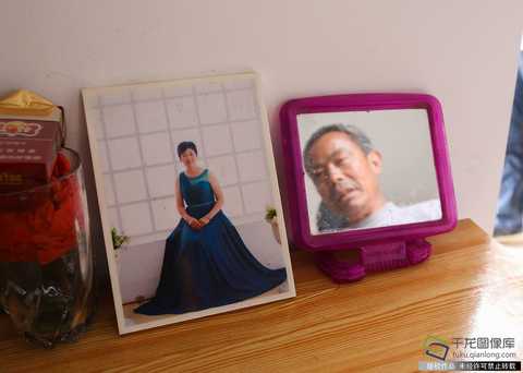 "I have to pay 2,500 yuan for each of my wife and my wife, and I have lived in a new home for a total of 5,000 yuan." Zhang Jianming said. The picture shows Zhang Jianming looking at his wife's photo (May 7 photo source: tuku.qianlong.com). Qianlong Net reporter