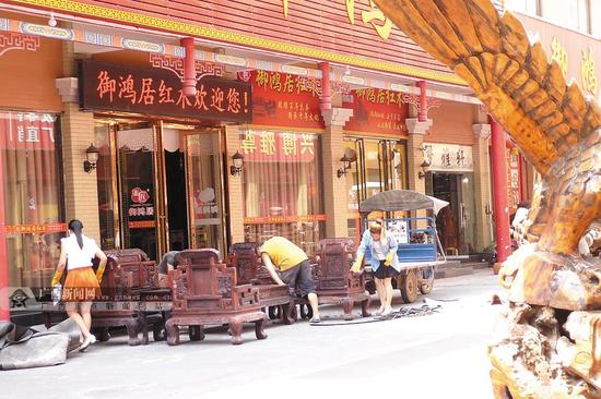 In May of this year, sales of Dongxing mahogany furniture improved. The picture shows the dealer handling the large fruit rosewood sofa that has been sold.