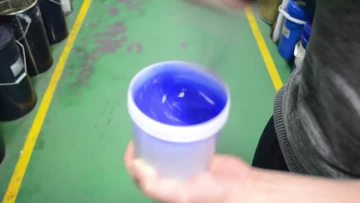 Real shot of manual stirring of blue liquid tank glue | raw material for filter sealing