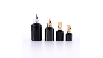 Black sloping shoulder glass bottle with gold and silver pump