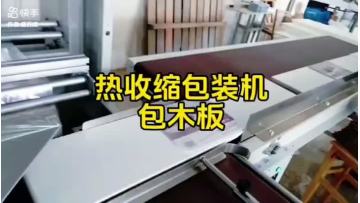 Heat shrink packaging machine for wrapping wooden boards