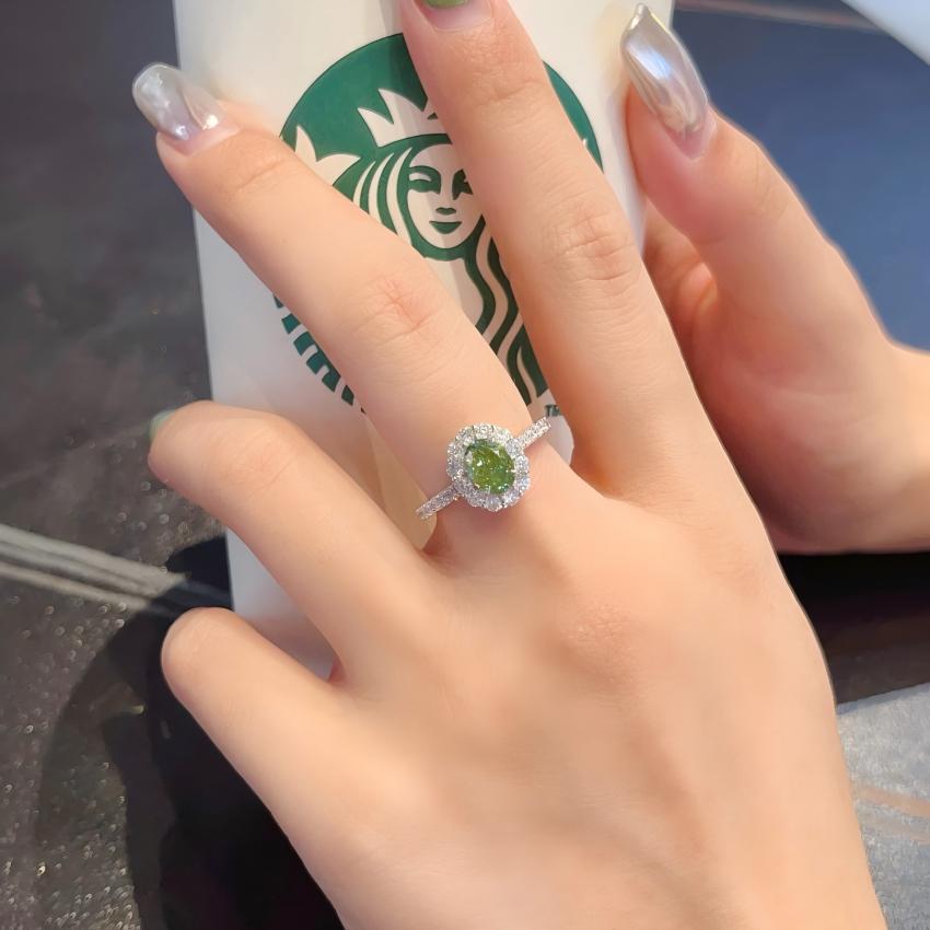 Fancy Vivid Green oval lab diamond halo ring with pave shoulders shown on hand