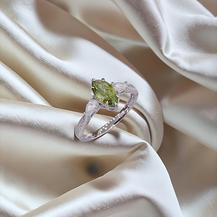 Angled view of green marquise lab diamond ring showing pear side stones and pave shoulders