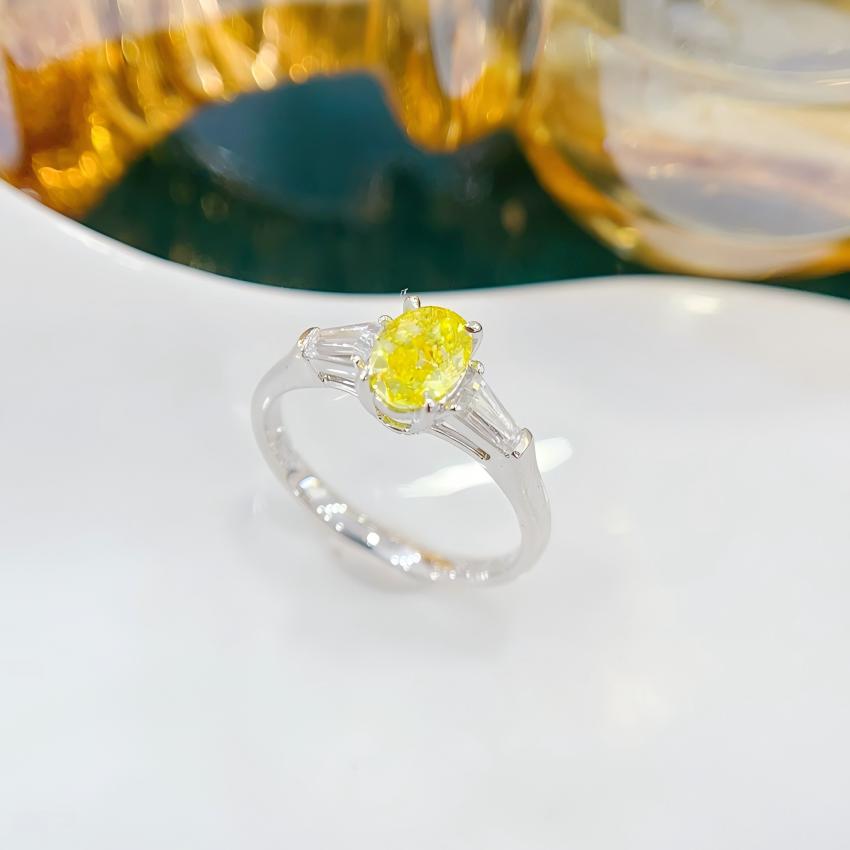 Front view of yellow oval lab diamond ring with matched tapered baguette shoulders