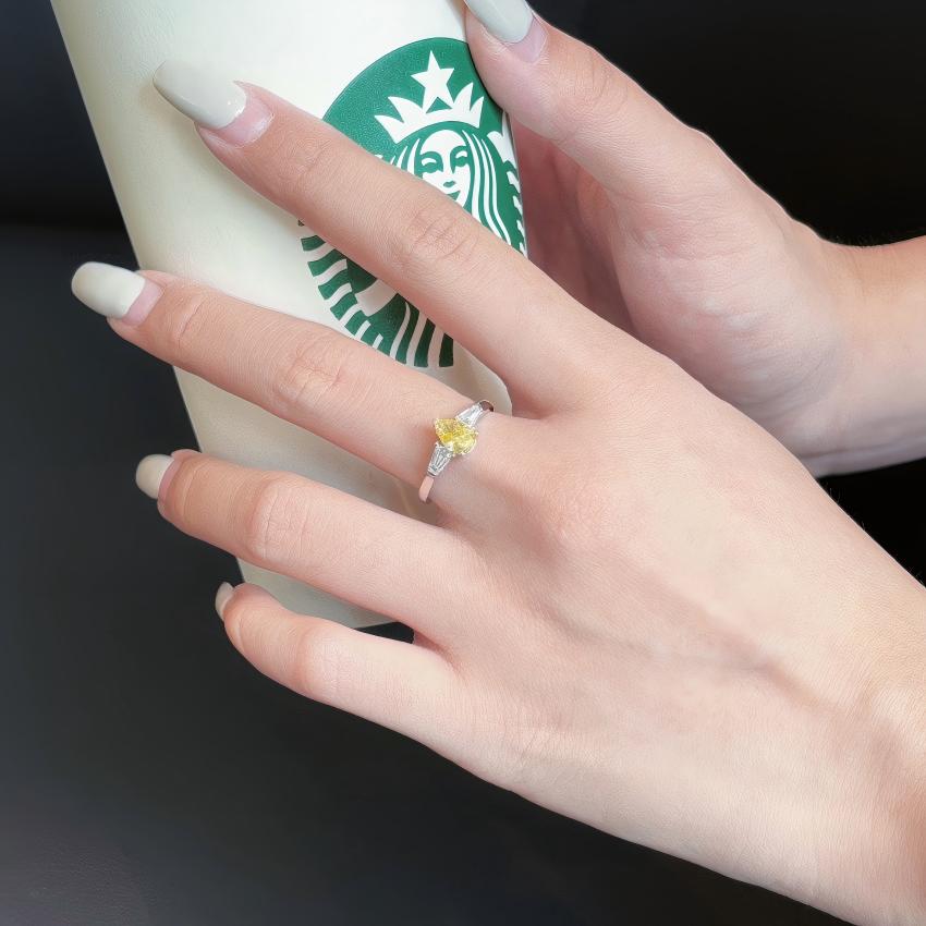 Yellow pear lab diamond three stone ring with tapered baguettes shown on hand