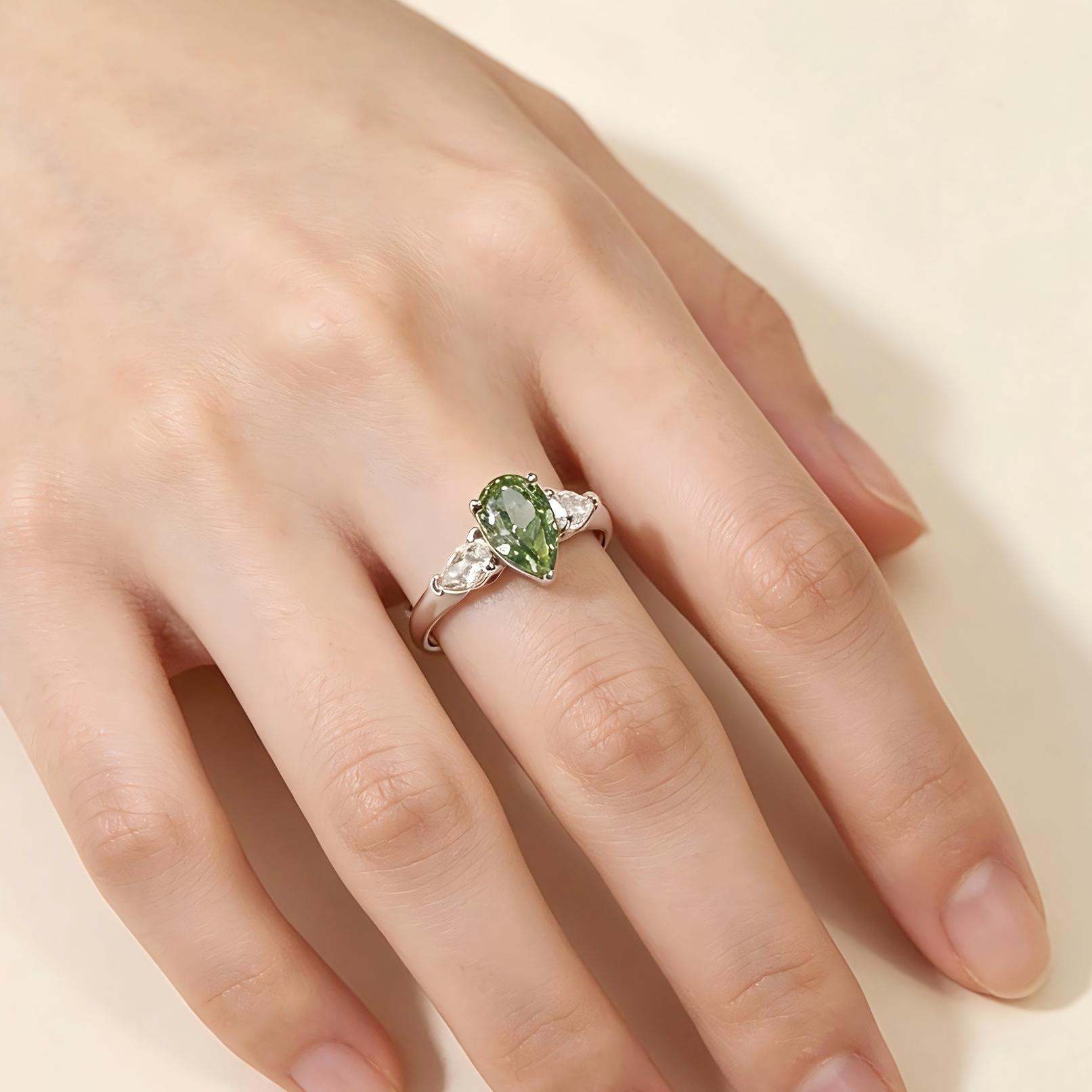 Fancy Vivid Green pear lab diamond three stone ring with pear side stones shown on hand