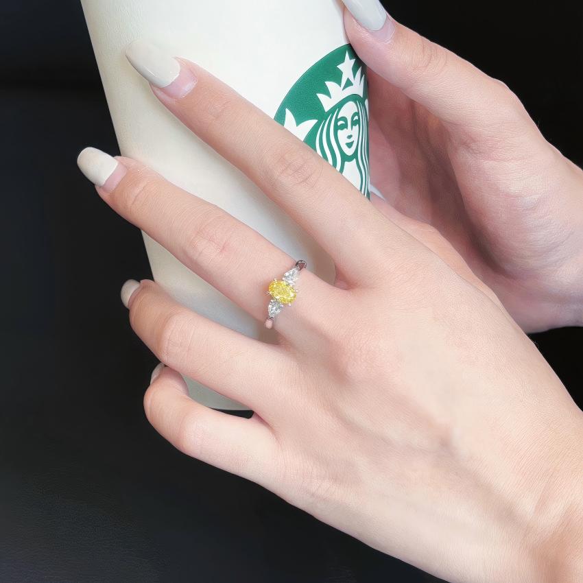 Compact yellow lab diamond three stone ring shown on hand
