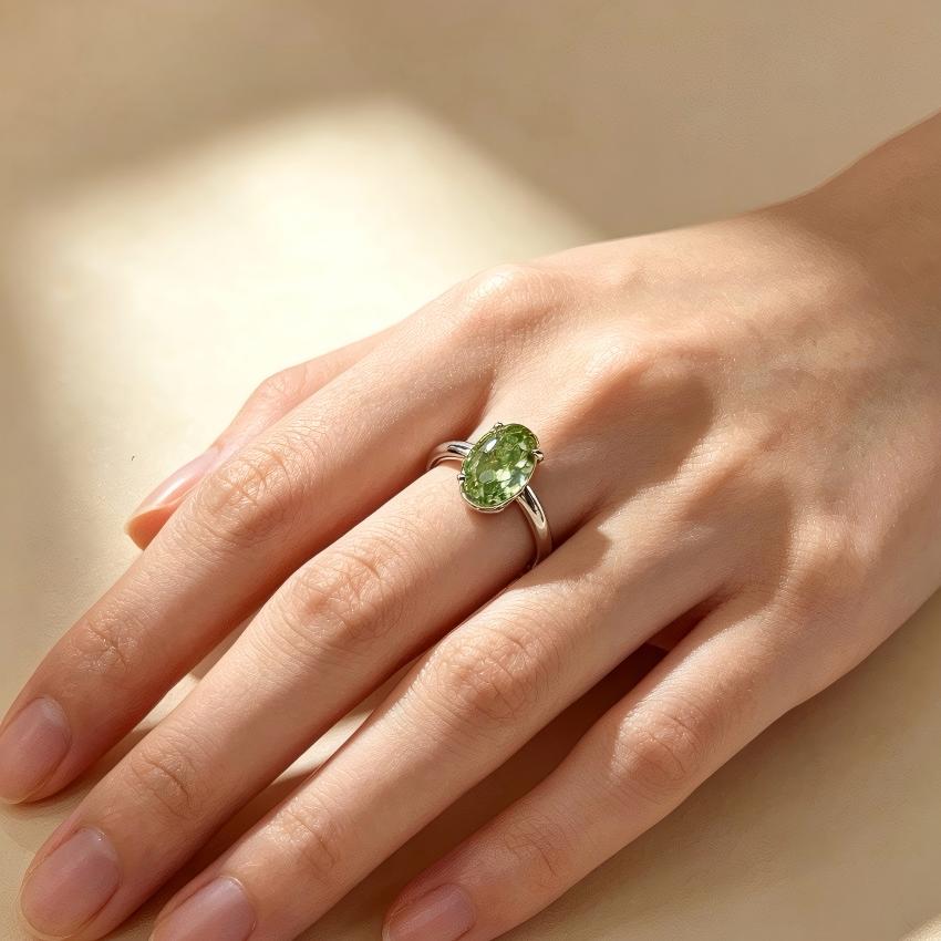 Fancy Vivid Green oval lab diamond solitaire ring shown on hand with polished shoulders