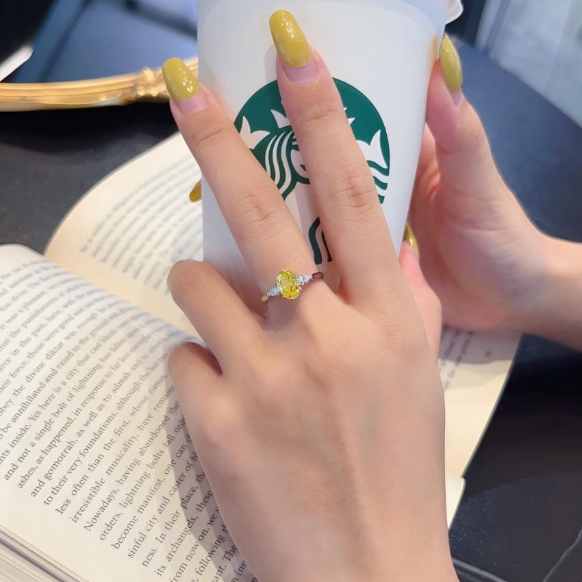 Vivid Yellow oval lab diamond trilogy ring with pear side stones shown on hand