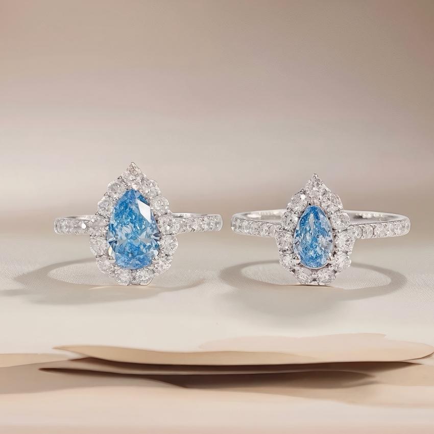 Two petite teardrop blue halo diamond rings shown side by side