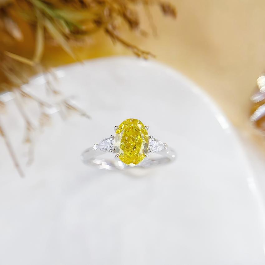 Fancy Vivid Yellow oval lab diamond trilogy ring with pear side diamonds in 18K white gold