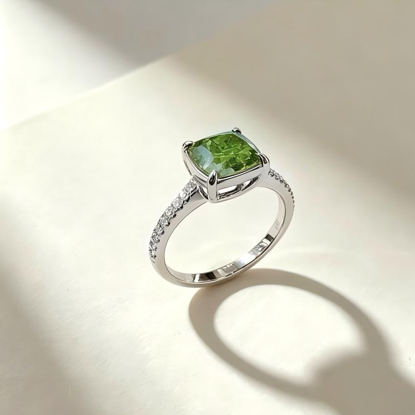 Angled view of green cushion lab diamond ring with pave shoulders and open gallery