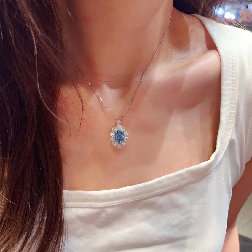 Oval blue diamond pendant worn on necklace