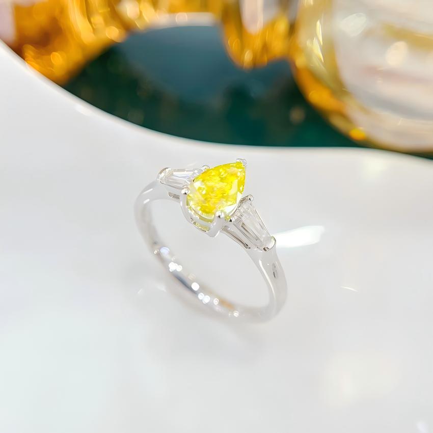 Yellow pear lab diamond ring with tapered baguette side stones in 18K white gold