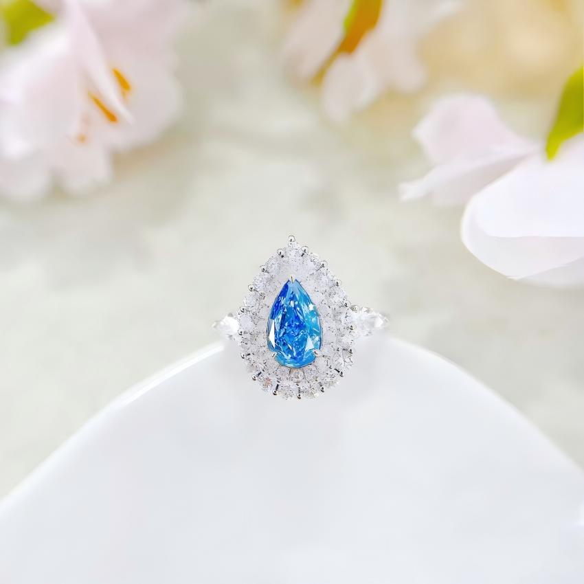 Front view pear blue halo ring with white accent stones