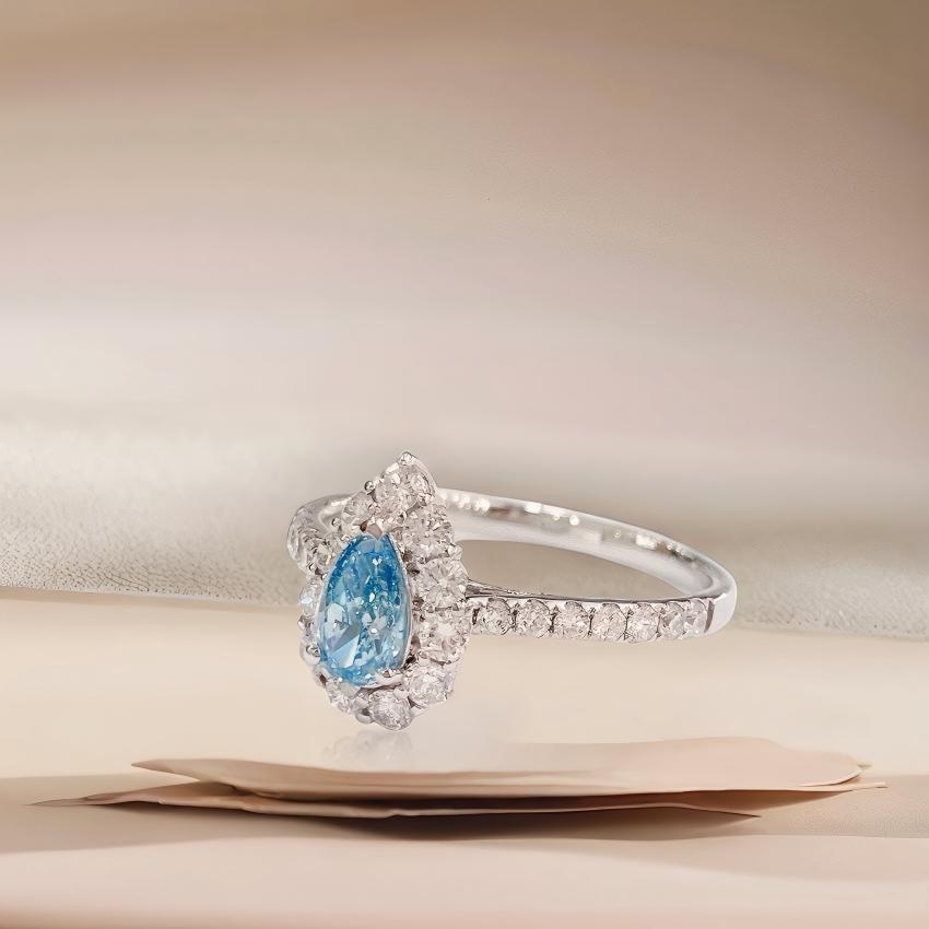 Profile view of teardrop blue halo ring with pavé band