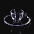 Beaded glass cup and saucer