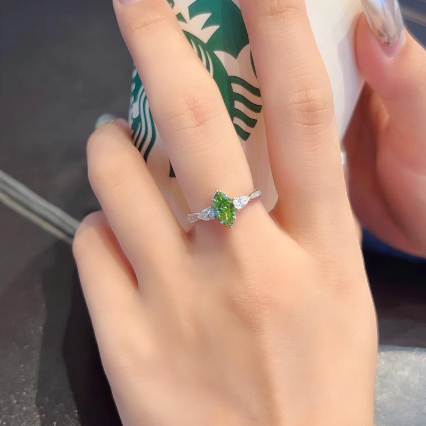 Green marquise lab diamond three-stone ring with pear side diamonds shown on hand